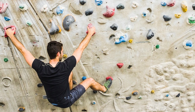 Homme pratiquant l&#39;escalade sur un mur artificiel à l&#39;intérieur. Concept de mode de vie actif.