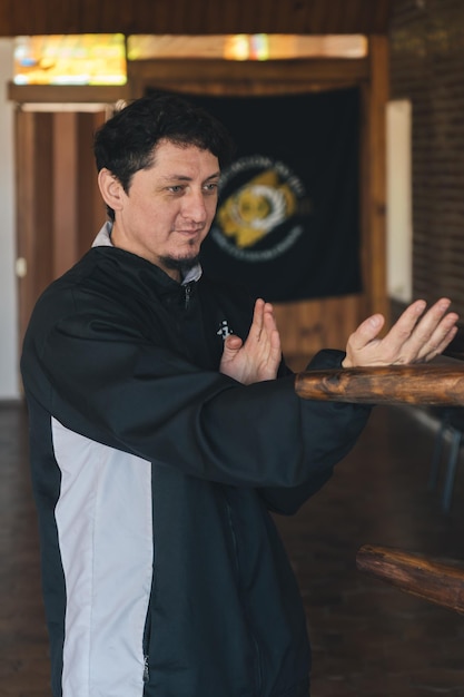 Photo un homme pratiquant la technique fondamentale du wing chun connue sous le nom de tan sao dans un studio d'arts martiaux