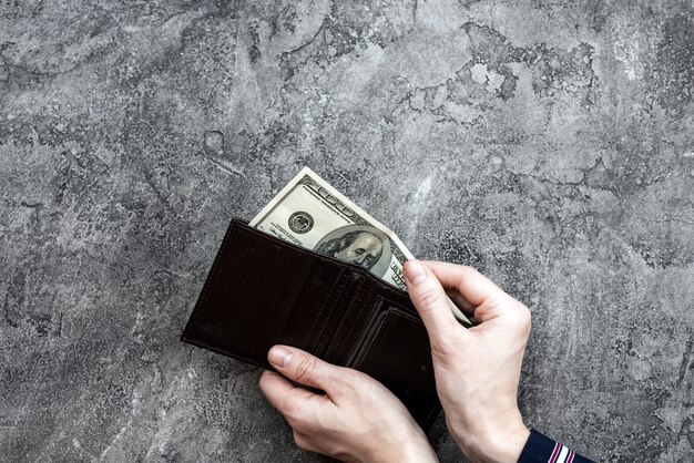 Homme prenant de l'argent de son portefeuille de poche vue de dessus