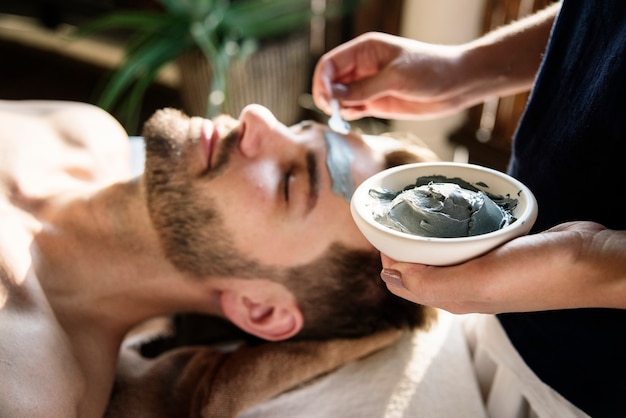 Homme prenant un masque de boue dans un spa