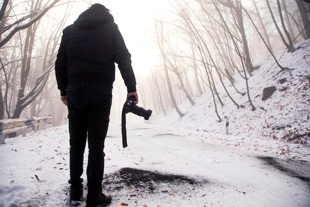 Photo un homme prenant une photo sur la neige en hiver