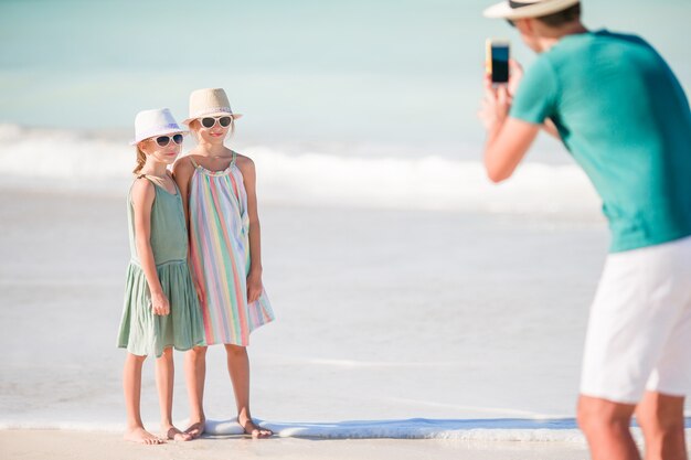 Homme prenant une photo de ses enfants sur la plage