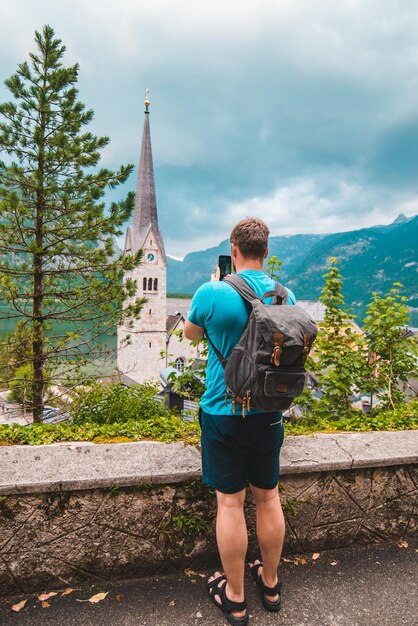 Homme prenant une photo de la ville de hallstatt depuis l'espace de copie ci-dessus