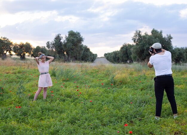 Homme prenant des photos de caméra d'une femme sur le terrain