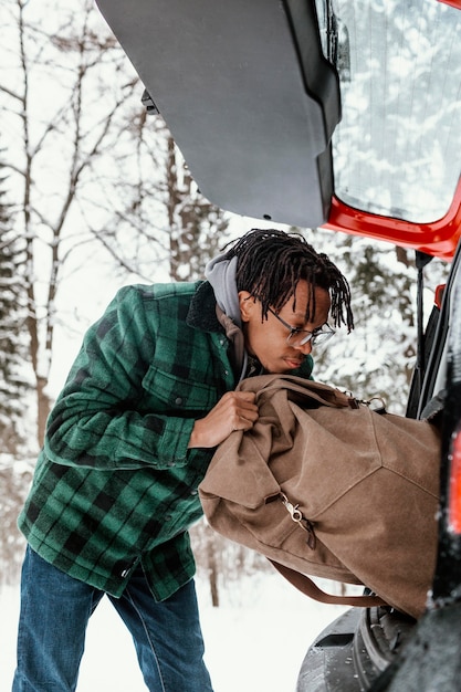 Homme prenant sac à dos de voiture