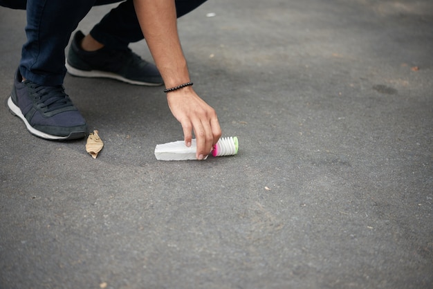 Homme prenant un sac hacky chinois du sol pour jouer au jeu jianzi