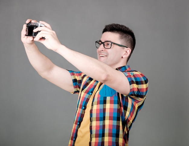 Homme prenant selfie isolé sur mur gris