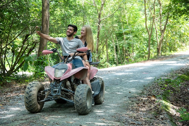 Homme prenant un selfie avec une petite amie en se tenant debout sur un VTT