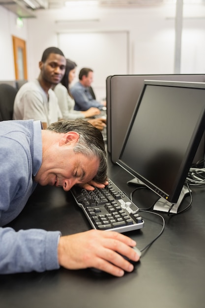 Homme prenant une sieste au cours d&#39;informatique