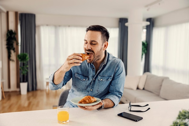 Un homme prenant son petit déjeuner dans sa maison confortable