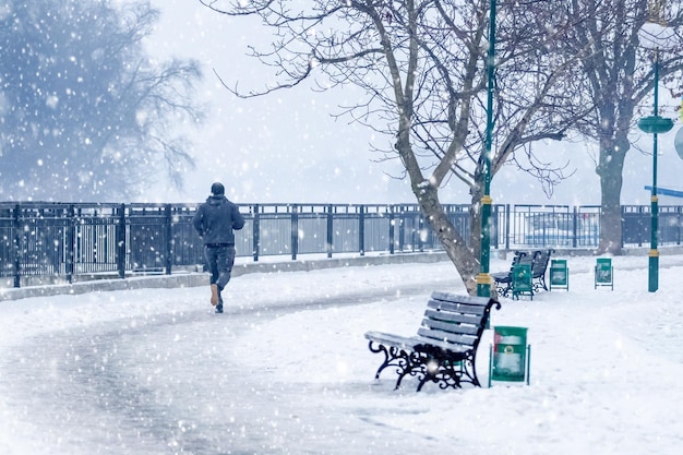 Un homme prend un jogging matinal dans un parc de la ville de Khmelnytskyi Ukraine lors d'une chute de neige