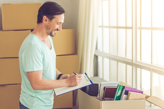 L'homme prend des notes en déménageant dans le nouvel appartement