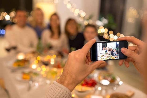 Un homme prend une photo de sa famille lors d'un dîner.