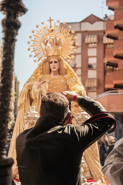 Photo un homme prend une photo d'une statue de la vierge du saint esprit