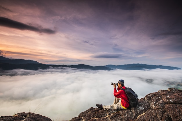 L&#39;homme prend des photos de la mer de brouillard sur la haute montagne.