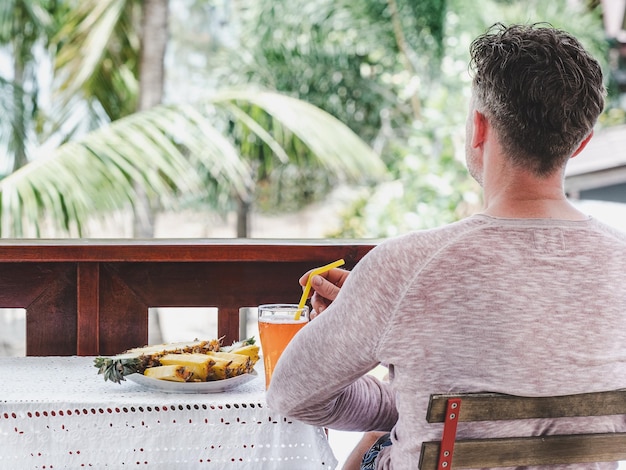 Un homme prend son petit déjeuner dans un restaurant d'hôtel en plein air