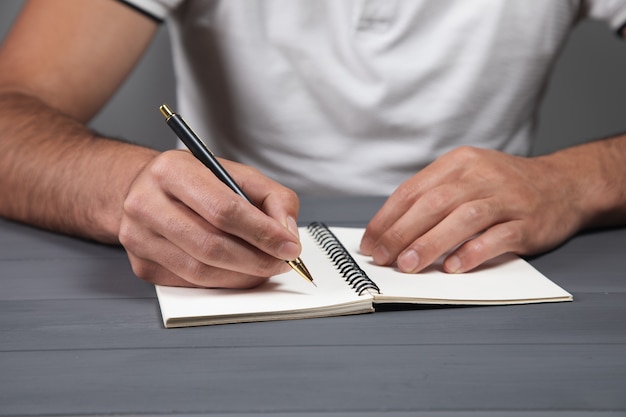 Homme, prendre des notes, dans, cahier, sur, mur gris