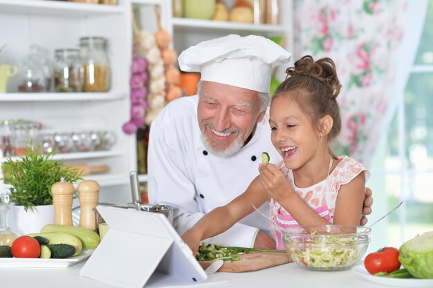 Homme préparant le dîner avec sa petite-fille