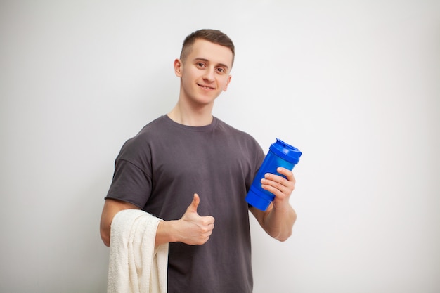 L'homme prépare une boisson protéinée dans le shaker après l'entraînement.