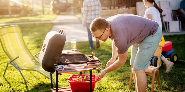 Homme prépare de la viande pour le grill.