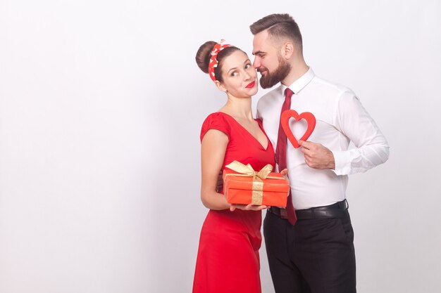 L'homme présente un coffret cadeau son amour à la Saint-Valentin. Intérieur, tourné en studio, isolé sur fond gris