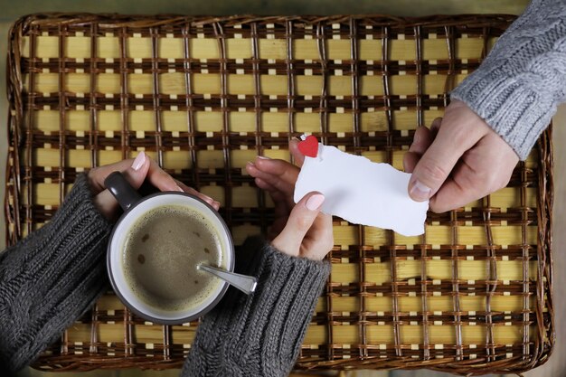 L'homme présente une fille qui boit un cadeau de café le jour de la Saint-Valentin