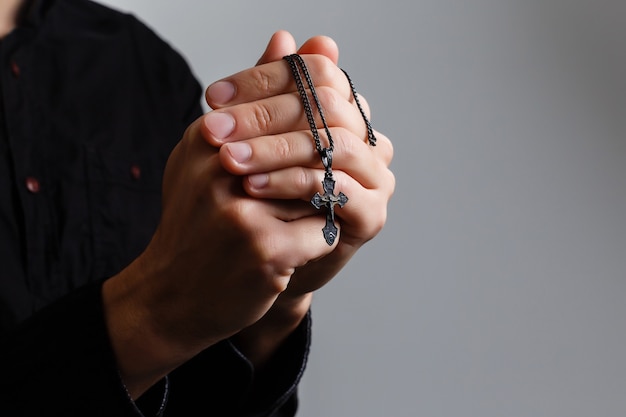 l'homme prie avec une croix sur fond noir