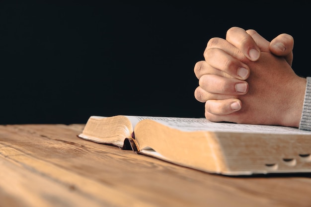 Photo homme de prière tenant une croix avec la bible