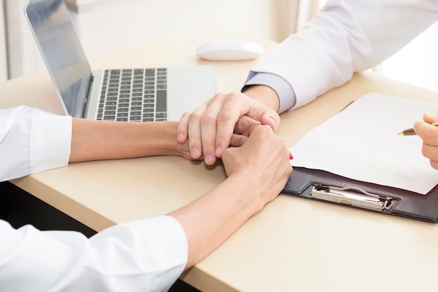 Un homme de professionnels de la santé rassurant et discutant avec une jeune femme inquiète un patient