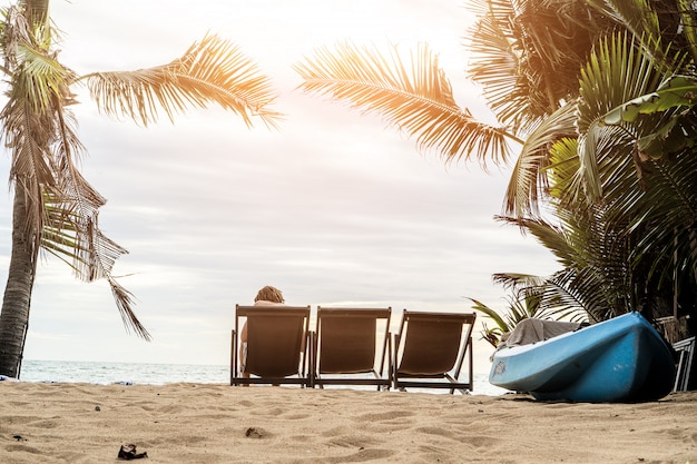 Photo un homme profitant de la vue imprenable sur la plage de sable tropicale avec ses palmiers verts et son bel océan