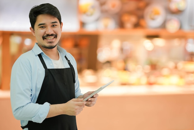 homme propriétaire d'entreprise tenant une tablette pour vérifier la commande du client