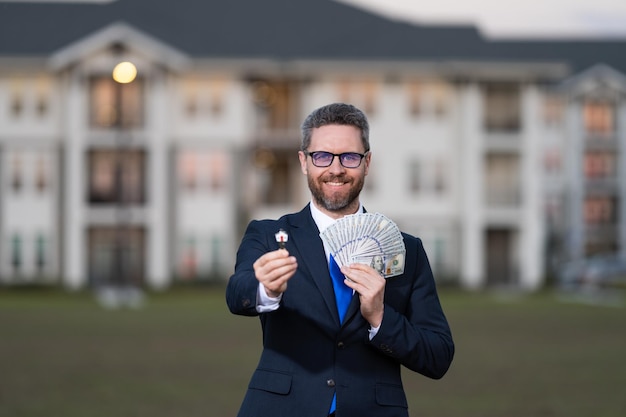 Photo l'homme propriétaire de la maison détient l'argent et la clé propriété propriétaire de la nouvelle maison propriétaire immobilier propriétaire d'une maison homme d'affaires vendeur de maison gérant ou agent immobilier coût de propriété