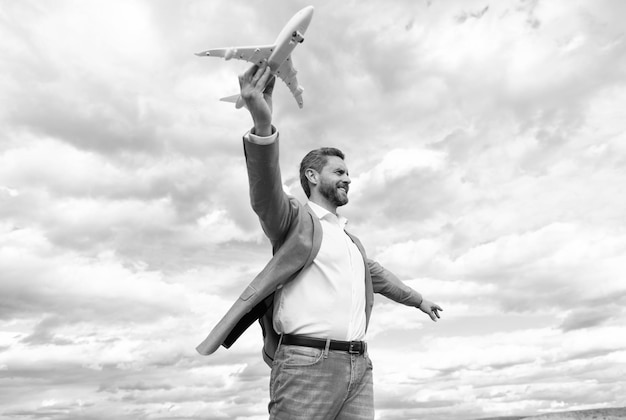 Homme prospère en costume rêvant entrepreneur prêt pour la liberté de voyage patron mature avec avion