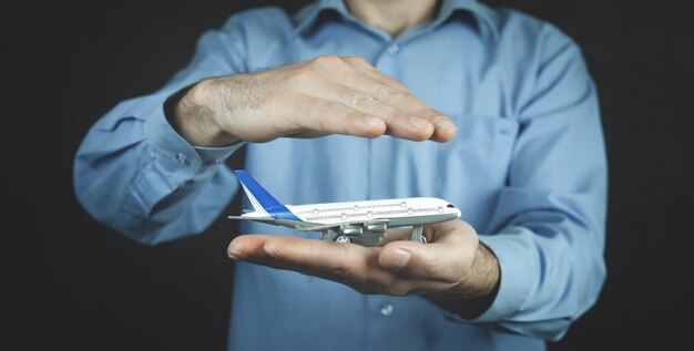 L'homme protège l'avion jouet. Assurance voyage