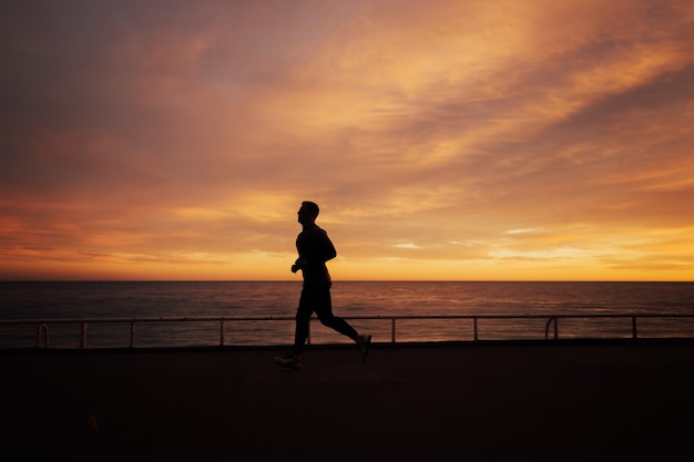 Homme qui court au coucher du soleil