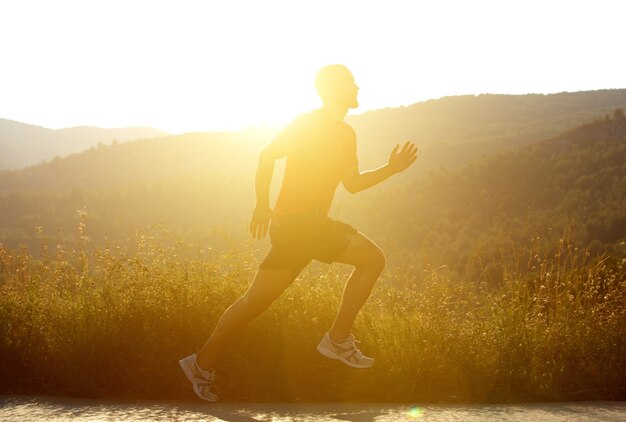 Homme qui court dehors avec coucher de soleil