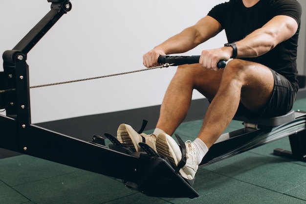 Homme qui court des exercices d'aviron dans la salle de sport