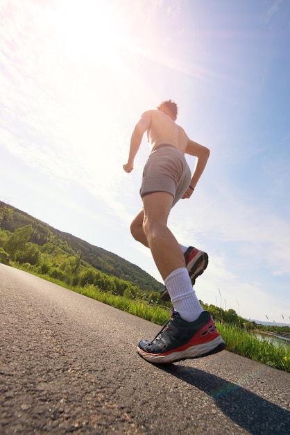 Un homme qui court sur la route contre le ciel