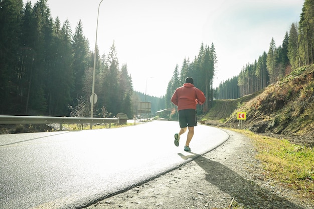 Homme qui court en route dans les montagnes des Carpates