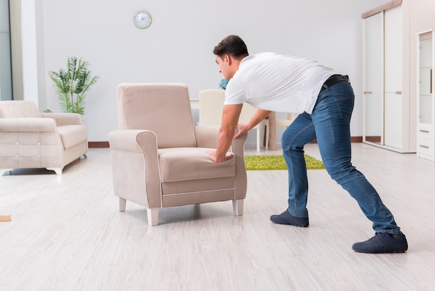 Homme qui déplace des meubles à la maison