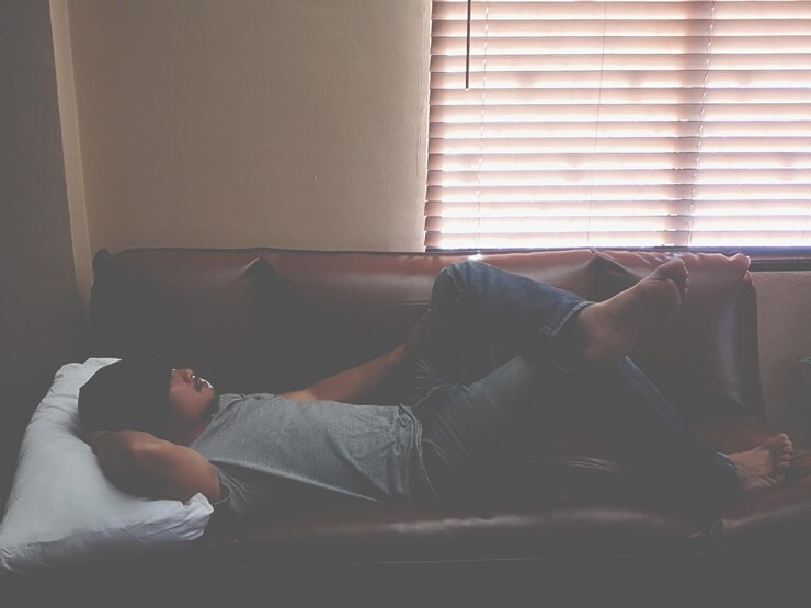 Photo un homme qui dort sur le canapé à la maison.