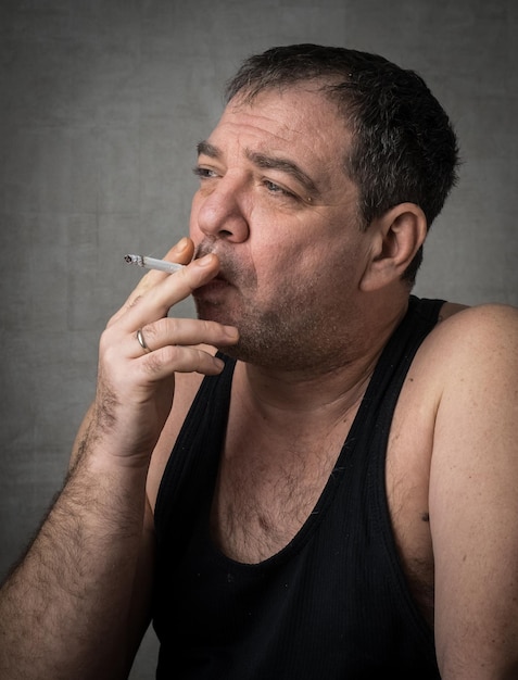 Un homme qui fume contre le mur.