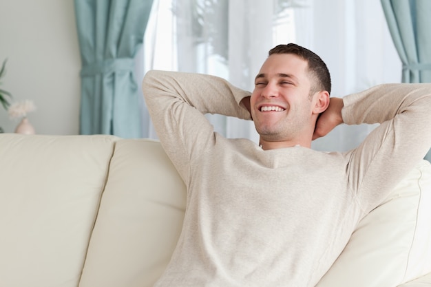 Homme qui rit relaxant sur un canapé