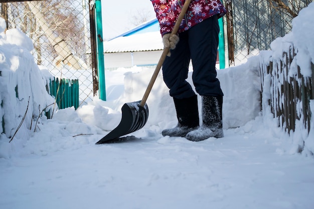 Un homme qui se tient dans la neige, la fille nettoie la neige avec une patte