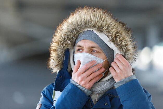 Homme qui tousse, portant un masque de protection médical