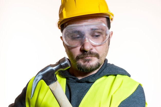 un homme qui veut faire un travail sans connaissance, un travail sans expérience. Faites-le vous-même, homme vêtu d'un casque de constructeur jaune avec des lunettes de protection prêt à commencer les travaux de construction