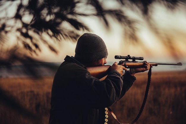 Un homme qui vise un fusil sur le terrain.
