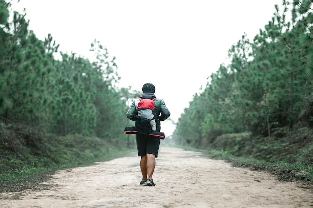 Homme qui voyage avec backpacker dans la forêt