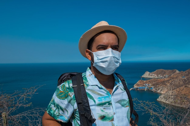 Un homme qui voyage porte un masque facial de protection contre les coronavirus