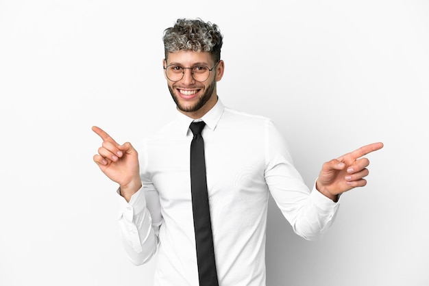 Homme de race blanche d'affaires isolé sur fond blanc, pointant le doigt vers les latéraux et heureux